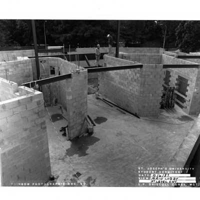 View of construction of McShain Hall with two workmen.