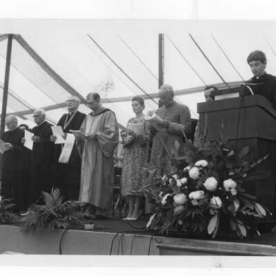 Edward Denion, S.J., giving invocation at academic convocation held on Gest Lawn, July 31, 1976, as part of SJC 125th anniversary celebration.