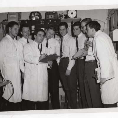 Several graduate chemistry students looking at charts in science laboratory, c. 1965.