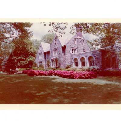 View of Regis Hall in spring with pink azaleas blooming.