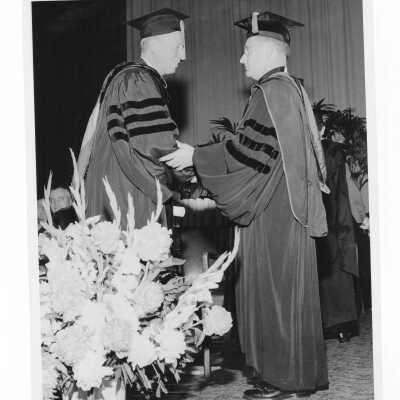 Edward G. Jacklin, S.J., congratulating honoree during 1956 graduation/commencement ceremony.