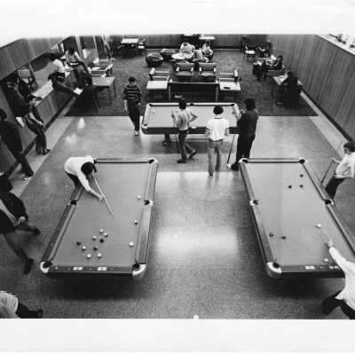 Students playing pool at three pool tables in student lounge.