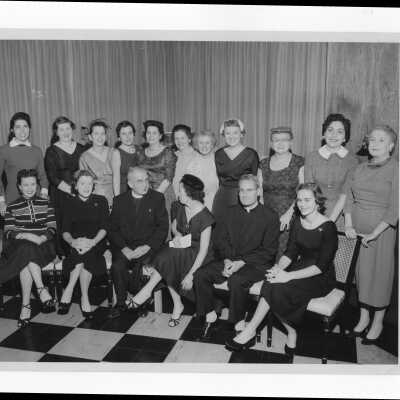 Michael Smith, S.J., and Joseph S. Hogan, S.J., with wives of alumni association members planning an event, January 5, 1958.