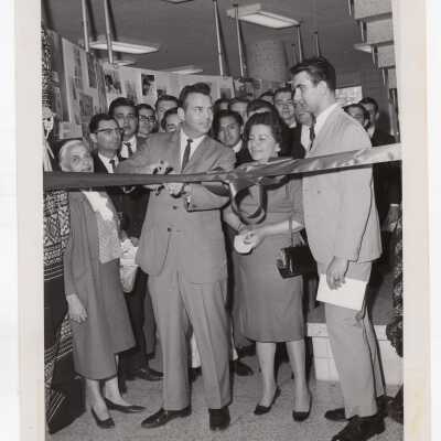 Anthony M. Swartz, Joseph Tozzi, Richard Arena, students, and others attending ribbon cutting for arts and crafts exhibit at Saint Joseph's College as part of month-long Pan American Observance, April 1965.