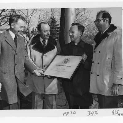 Terrence Toland, S.J., and SJC Vice President, Daniel DeLucca accepting certificate from representatives of American Revolution Bicentennial Committee during 125th anniversary of Saint Joseph's College in 1976.