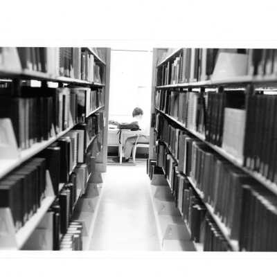 View of student studying at desk from stacks of Drexel Library.