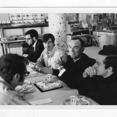 Terrence Toland, S.J., with students and in classroom.