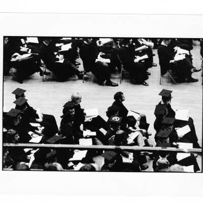 Graduates during 1971 graduation/commencement ceremony with peace symbol on caps.
