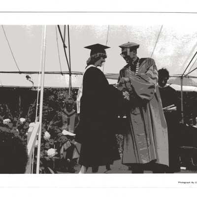 Donald I. MacLean, S.J. awarding diploma to graduating student during 1980 graduation/commencement.