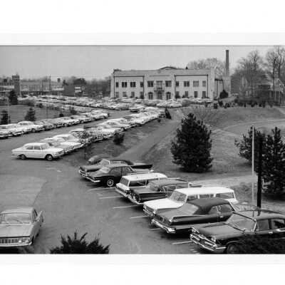 View of Field House (Sports Complex) from parking lot with cars.