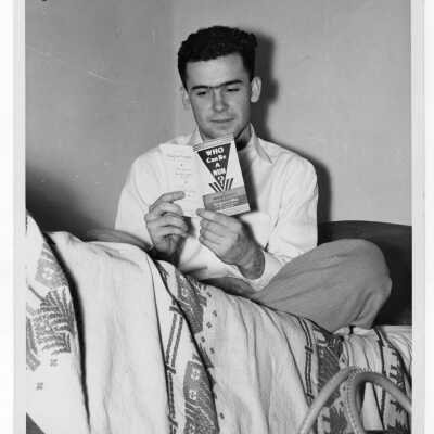 Student resident of Quirk Hall reading "Who Can Be a Nun" in dormitory room.