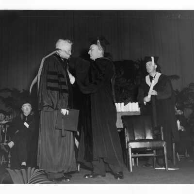Edward G. Jacklin, S.J. bestowing honorary degree on Judge James C. Ganey with Michael Boland and others watching during 1952 graduation/commencement.