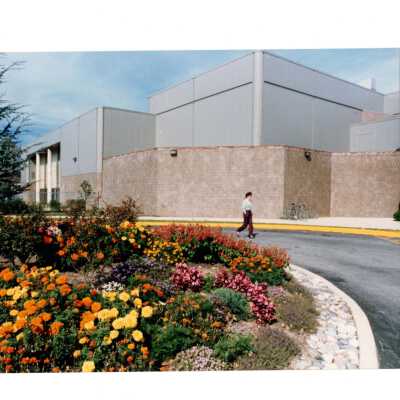 Exterior view of Sports Complex with drive around circle planted in chrysanthemums.