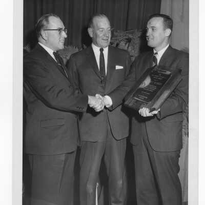 Joseph F. McKinney receiving Hogan Alumni Award with John Clark and William F. Kelly watching, February 27, 1963.
