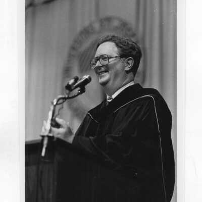 Thomas McFadden (Dean) in academic robe; and Thomas McFadden talking with two students in office in Barbelin.
