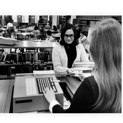 Interior view of Drexel Library with student checking out books anad other students studying at desks.