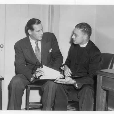 Edward G. Jacklin, S.J. talking with Maurice J. Tobin, U.S. Secretary of Labor during labor symposium on industrial relations held October 26, 1951 in Flanigan Auditorium during centennial celebration.
