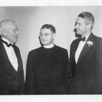 Edward G. Jacklin, S.J., with toastmaster, John J. Sullivan (class of 1896) and speaker during banquet held in Field House as part of centennial anniversary celebration.
