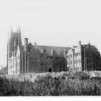Exterior view of southern façade of Barbelin building near end of construction with supply wagon and truck.