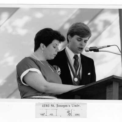 View of two students at podium during Baccalaureate service, graduate/commencement, c. 1985.