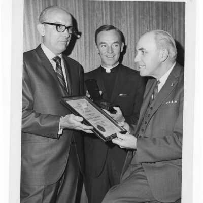 Shaffrey award recipient, Dr. Peter A. Herbut, showing medal and certificate to Terrence Toland, S.J., and another individual, April 19, 1970.