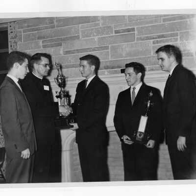 Students from Villiger Debating Society presenting trophy to Jesuit moderator.