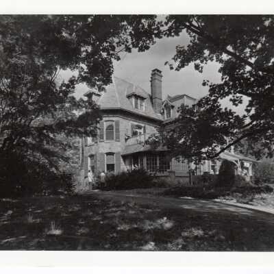 Exterior view of Quirk Hall with students on first floor and second floor porches.