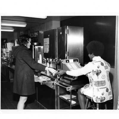 Female student paying cashier for meal in Campion cafeteria.