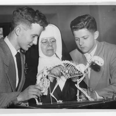 Two high school students and nun viewing animal skeleton in science laboratory during an open house held on March 17, 1951 as part of centennial celebration. The event was billed as 'One Hundred Years and a Day of Science.'
