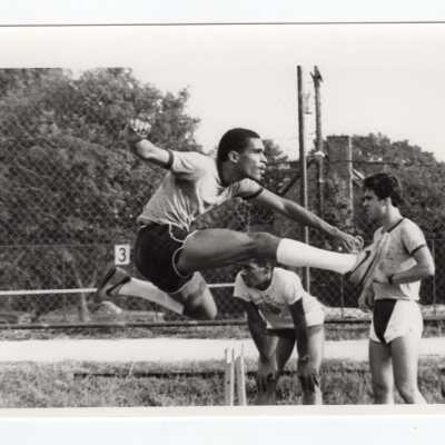 Men's track team in hurdles event.