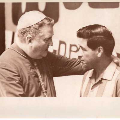Pax Romana's 20th World Plenary Assembly meets at Saint Joseph's College, August 1968. Cesar Chavez in conversation with a Bishop.