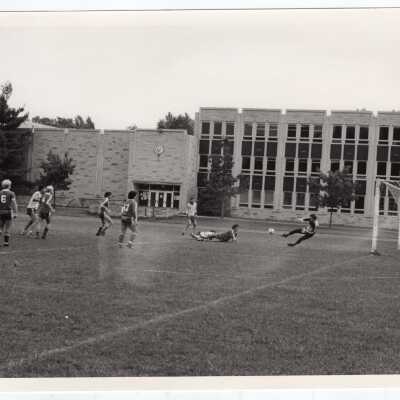 Men's soccer match with Post Hall (formerly Villiger) in background.