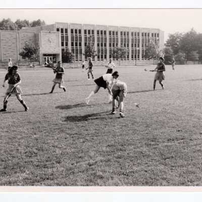 Women's field hockey match on Finnesey Field with Post Hall (formerly Villiger) in background.