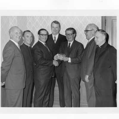 Richard J. Hughes receiving Law Alumni Award with Terrence Toland, S.J., and others watching, December 2, 1969.