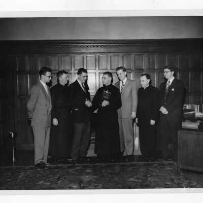 Student members of Villiger Debating Society, Matthew G. Sullivan, S.J., and Father Gibbons presenting trophy to Edward G. Jacklin, S.J., president of Saint Joseph's College.