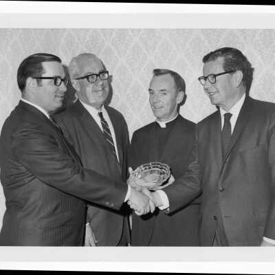 Richard J. Hughes receiving Law Alumni Award with Terrence Toland, S.J., and others watching, December 2, 1969.
