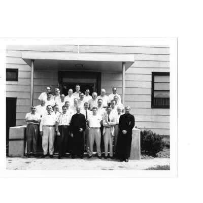 Summer alumni spiritual retreat on SJC campus, c. 1958, including Michael J. Smith, S.J. View of attendees standing in front of Cardboard College.