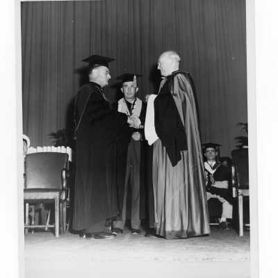 Edward G. Jacklin, S.J. conferring honorary degree on Monsignor John J. Daly during 1955 graduation/commencement.