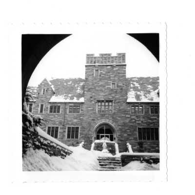 Exterior view of central arch and Blessed Virgin statue and World War Two memorial in Barbelin quandrangle in the snow.