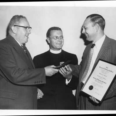 Dr. Charles P. Bailey showing Shaffrey award medal to Edward G. Jacklin, S.J., June 3, 1951.