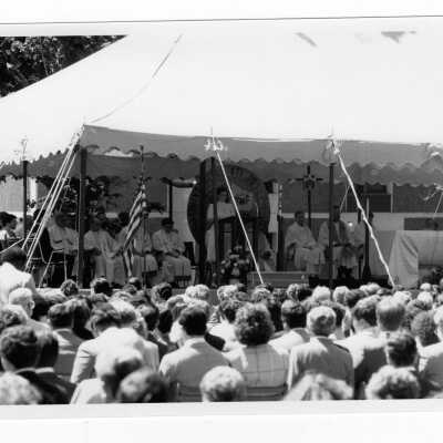 View of student speaker during outdoor Baccalaureate service, graduation/commencement, c. 1985.