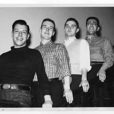 Four student residents of Quirk Hall standing on stairway.