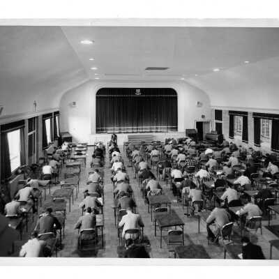 Flanigan Auditorium, Field House (Sports Complex) with students seated at individual folding tables taking test?