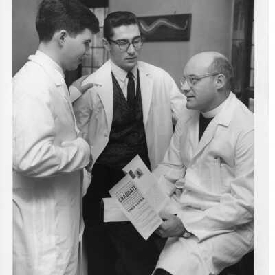 Biology professor, Paul R. Beining,S.J., advising two students.