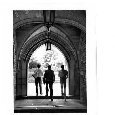 Three students walking through lower archway of Barbelin building.