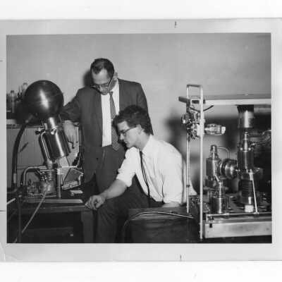 Student and instructor in science laboratory conducting an experiment.