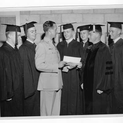 Tropaia exercises during 1955 graduation/commencement with Edward G. Jacklin, S.J., Colonel Ray Gehrig, and five graduating students.