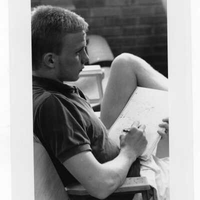 Male student taking notes during lecture.