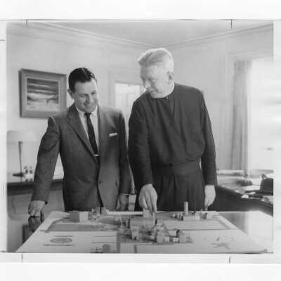 Lawrence R. McHugh, S.J., looking at model of campus with Joseph Pascucci.