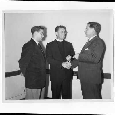 Edward G. Jacklin, S.J, receiving Fourth Annual Giving check from alumni officers, William Ariano and Francis Lammer, c. 1953.